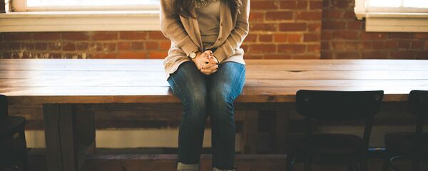 Девушка сидит на столе, архивное фото - Sputnik Тоҷикистон