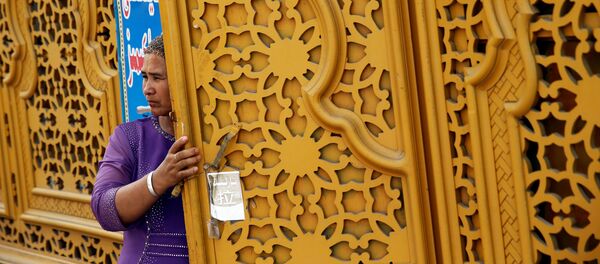 Женщина у двери в Старом городе в Кашгаре Синьцзян-Уйгурского автономного района Китая Женщина у двери в Старом городе в Кашгаре Синьцзян-Уйгурского автономного района Китая - Sputnik Таджикистан