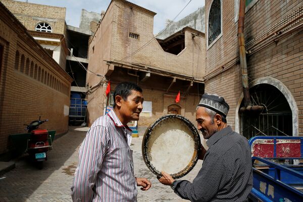 Мужчина продает музыкальный инструмент в Старом городе в Кашгаре, Синьцзян-Уйгурского автономного района Китая - Sputnik Таджикистан