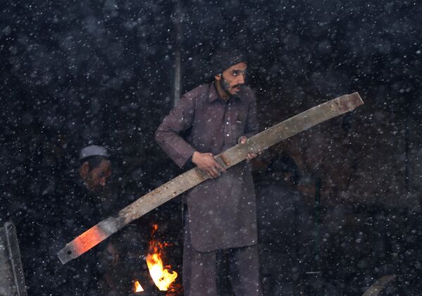 Кузнец работает в своей мастерской во время снегопада в Кабуле - Sputnik Таджикистан