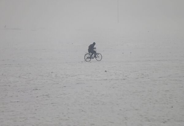 Афганец едет на велосипеде во время снегопада в Кабуле - Sputnik Таджикистан