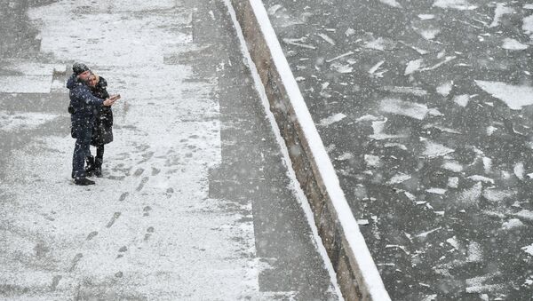 Молодые люди на набережной Москвы-реки во время снегопада в Москве, архивное фото - Sputnik Тоҷикистон