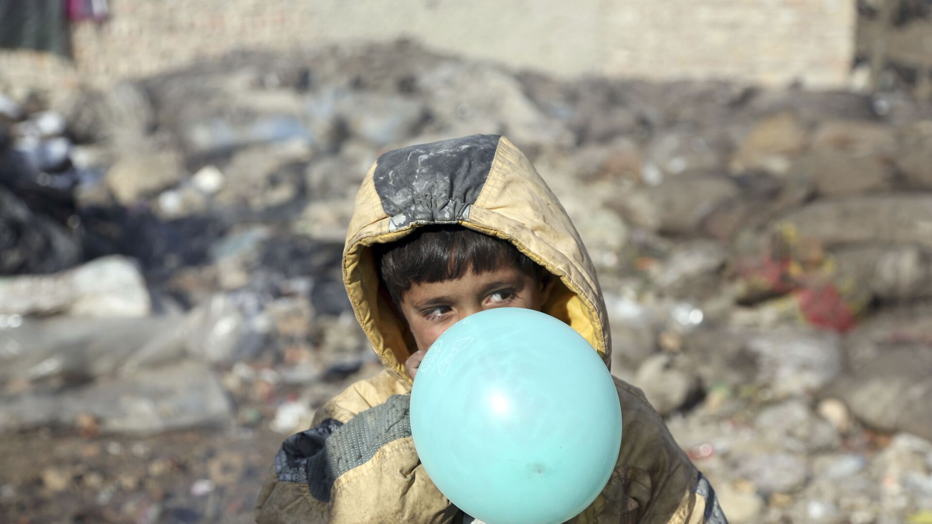Афганский мальчик надувает воздушный шарик, окраина Кабула, Афганистан, 2017 год - Sputnik Таджикистан, 1920, 17.08.2022