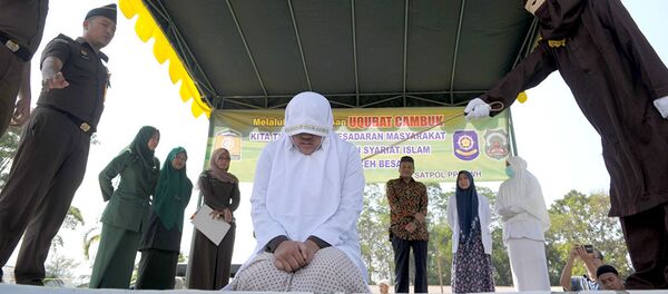 Избиение женщины из народа ачех по законам шариата, архивное фото Избиение женщины из народа ачех по законам шариата, архивное фото - Sputnik Таджикистан