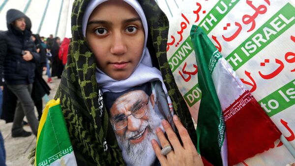Иранская девушка с портретом Высшего руководителя страны Али Хаменеи с надписями Долой США! и Долой Израиль! во время мероприятий по случаю празднования 40-й годовщины исламской революции в Тегеране - Sputnik Таджикистан