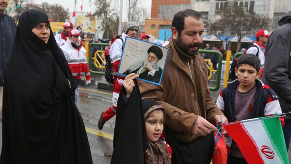 Девочка держит портрет верховного лидера страны Али Хаменеи во время церемонии, посвященной 40-летию Исламской революции - Sputnik Таджикистан
