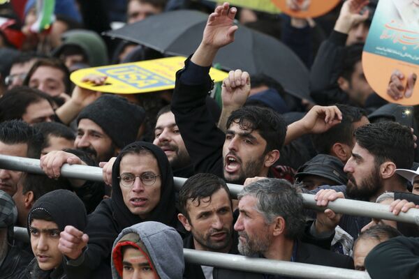Иранцы слушают выступление президента Хасана Рухани во время церемонии, посвященной 40-летию исламской революции, на площади Свободы в Тегеране - Sputnik Таджикистан