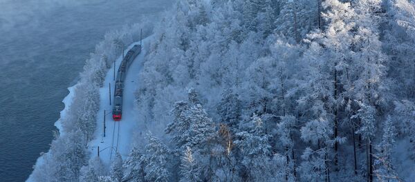 Пассажирский поезд движется вдоль берега реки Енисей близ Красноярска, Россия Пассажирский поезд движется вдоль берега реки Енисей близ Красноярска, Россия - Sputnik Таджикистан