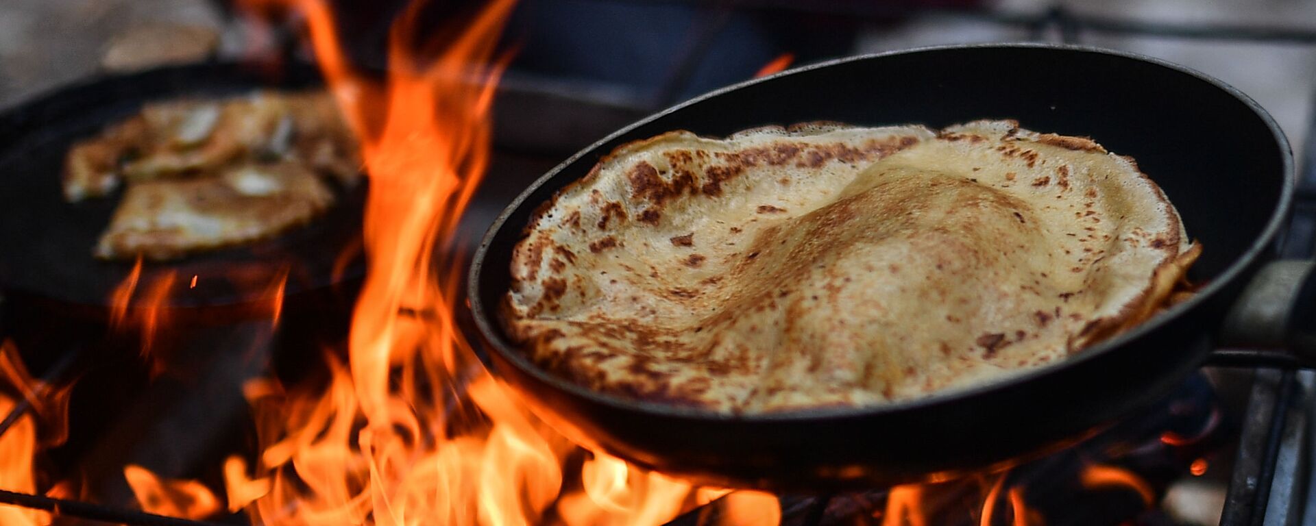 Приготовление блинов на костре во время празднования Масленицы - Sputnik Таджикистан, 1920, 09.03.2021