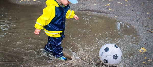 Ребенок бегает по луже, архивное фото - Sputnik Таджикистан
