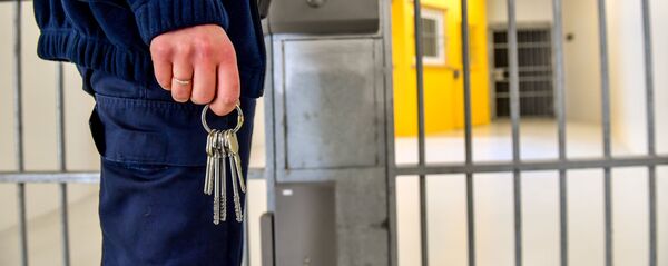 Тюремный охранник стоит перед тюремной решеткой - Sputnik Тоҷикистон