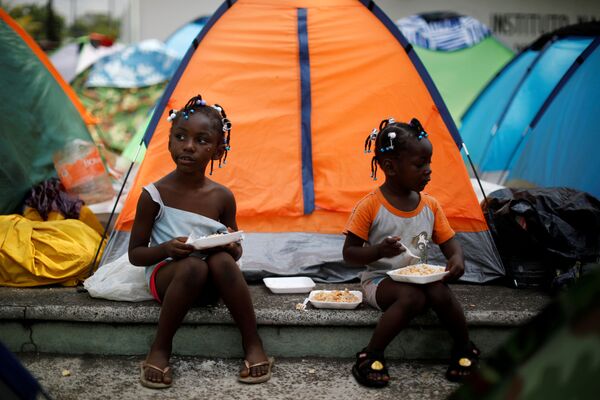 Девочки из Конго едят возле своей палатки в импровизированном лагере рядом с Национальным институтом миграции (INM) в Тапачуле, Мексика - Sputnik Таджикистан