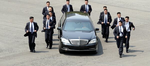 Северокорейские телохранители бегают трусцой рядом с автомобилем с лидером Северной Кореи Ким Чен Ыном - Sputnik Таджикистан