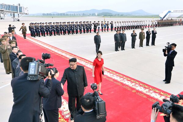 Cеверокорейский лидер Ким Чен Ын и его жена Ри Сол Джу (центр R) прибывают в международный аэропорт Пхеньяна - Sputnik Таджикистан