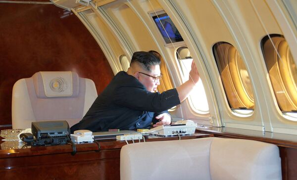 Северокорейский лидер Ким Чен Ын (С), машущий китайским чиновникам с самолета  - Sputnik Таджикистан