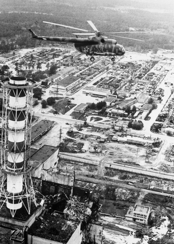 Вертолет производит радиологические измерения над зданием Чернобыльской АЭС после катастрофы - Sputnik Тоҷикистон
