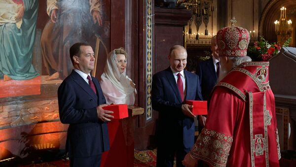 Президент РФ В. Путин и премьер-министр РФ Д. Медведев на пасхальном богослужении в храме Христа Спасителя - Sputnik Таджикистан
