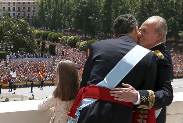 Испанский король Фелипе VI обнимается с бывшим королем Испании Хуаном Карлосом, в то время как принцесса София машет с балкона  - Sputnik Таджикистан