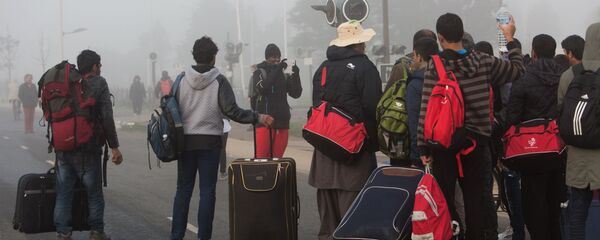 Беженцы в специально организованном центре по распределению мигрантов - Sputnik Тоҷикистон