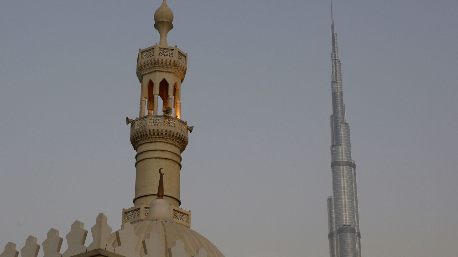 Самая высокая башня в мире, Бурдж-Халифа, видна за минаретом в Дубае - Sputnik Тоҷикистон, 1920, 17.07.2022