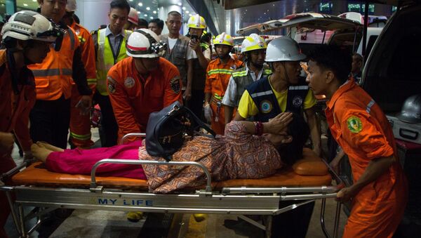 Спасатели перевозят раненого пассажира на носилках после того, как пассажирский самолет авиакомпании Biman Bangladesh соскользнул с взлетно-посадочной полосы - Sputnik Таджикистан