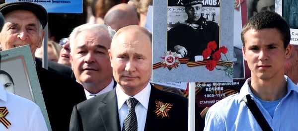 Президент РФ Владимир Путин с портретом своего отца-фронтовика Владимира Спиридоновича принимает участие в шествии патриотической акции Бессмертный полк - Sputnik Таджикистан