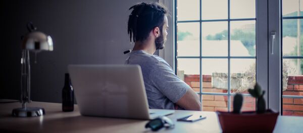 Мужчина смотрит в окно у рабочего стола Мужчина смотрит в окно у рабочего стола - Sputnik Таджикистан