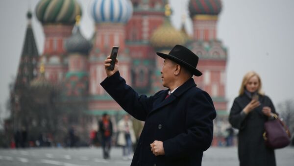 Турист фотографируется на Красной площади в Москве - Sputnik Таджикистан