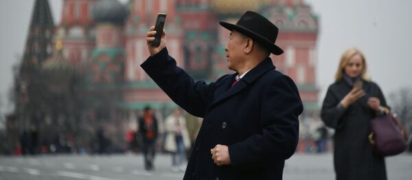 Турист фотографируется на Красной площади в Москве - Sputnik Таджикистан