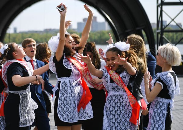 Выпускники средних школ гуляют после празднования последнего звонка на Михайловской набережной в Новосибирске - Sputnik Таджикистан