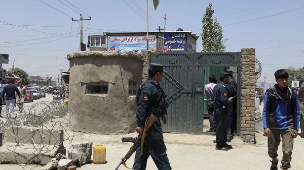 Сотрудник афганских сил безопасности идет перед контрольно-пропускным пунктом безопасности после нападения на окраину Кабула, Афганистан - Sputnik Таджикистан