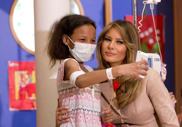 Девочка делает селфи с первой леди США Меланией Трамп в детской больнице Queen Fabiola в Брюсселе - Sputnik Таджикистан