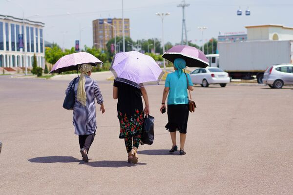 Если на улице +35, а на работу идти все-таки надо, единственным средством защиты от палящих солнечных лучей становится зонтик  - Sputnik Таджикистан