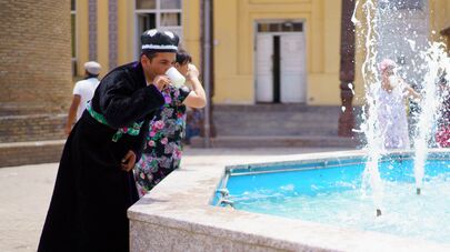 Мужчина пьет холодную воду из фонтана