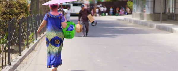 Женщина идет с зонтиком защищаясь от солнца - Sputnik Тоҷикистон