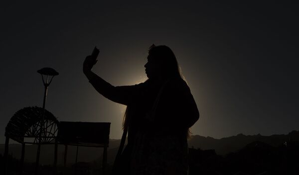 Женщина фотографируется во время солнечного затмения в Боливии - Sputnik Таджикистан