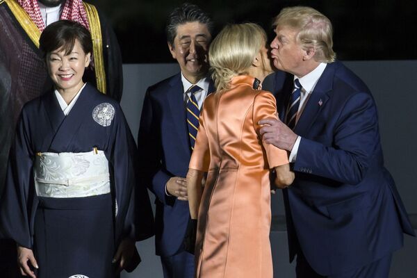 Президент США Дональд Трамп целует первую леди Франции Бриджит Макрон на саммите G20 в Осаке - Sputnik Таджикистан