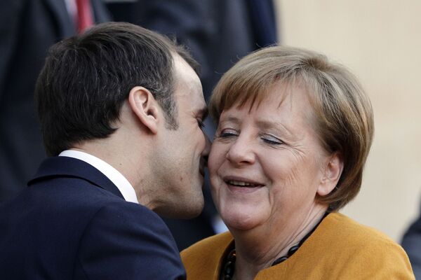 Президент Франции Эммануэль Макрон целует канцлера Германии Ангелу Меркель в Париже - Sputnik Таджикистан