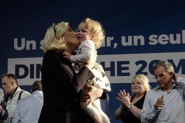 Марин ле Пен целует девочку во время предвыборного митинга в Энен-Бомоне, Франция - Sputnik Таджикистан