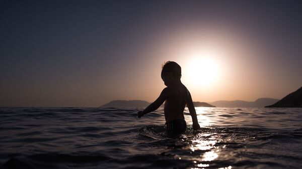 Ребенок в воде на закате, архивное фото - Sputnik Таджикистан