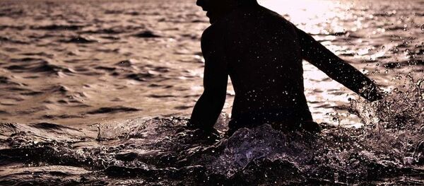 Мальчик купается в воде на закате, архивное фото - Sputnik Тоҷикистон