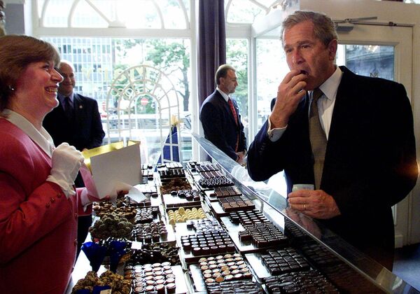 Президент Джордж Буш пробует конфеты в магазине шоколада в Брюсселе, Бельгия - Sputnik Таджикистан