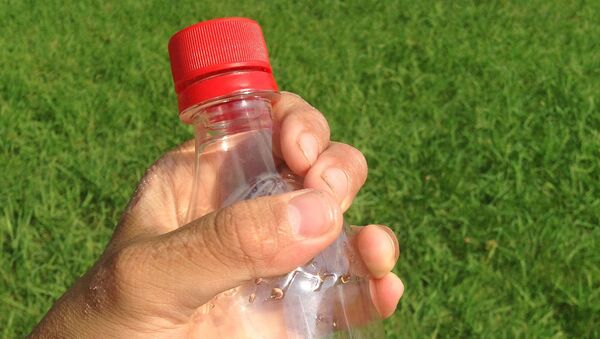 Пластиковая бутылка в руке, архивное фото - Sputnik Таджикистан