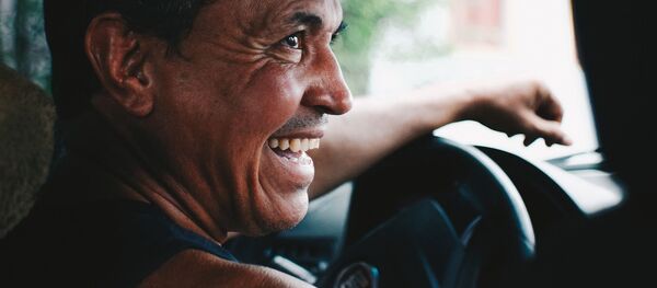 Мужчина за рулем автомобиля смеется - Sputnik Таджикистан