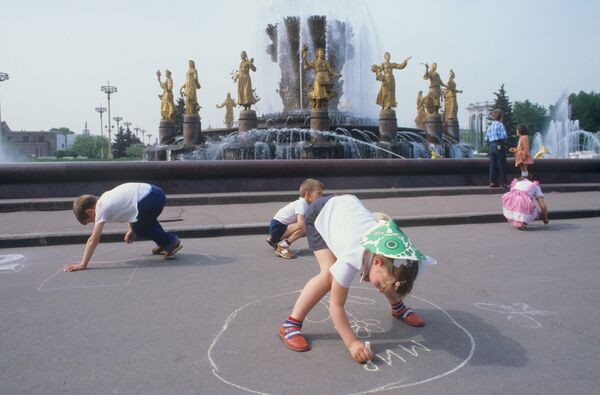 Дети рисуют мелом на асфальте у фонтана Дружба народов в Москве. 1984 - Sputnik Таджикистан