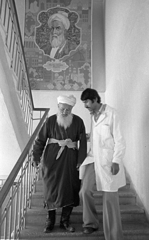 Экс-главный врач по лечебной части курорта Ходжа-Оби-Гарм Нарзулло Мирзомуратов (справа) с 84-летним пациентом - Sputnik Таджикистан