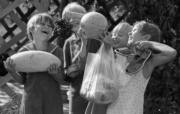 Воспитанники Ташкентского детского дома держат в руках дыню, арбуз, виноград и персики, которые они сами вырастили на своем приусадебном участке, 1983 год - Sputnik Таджикистан