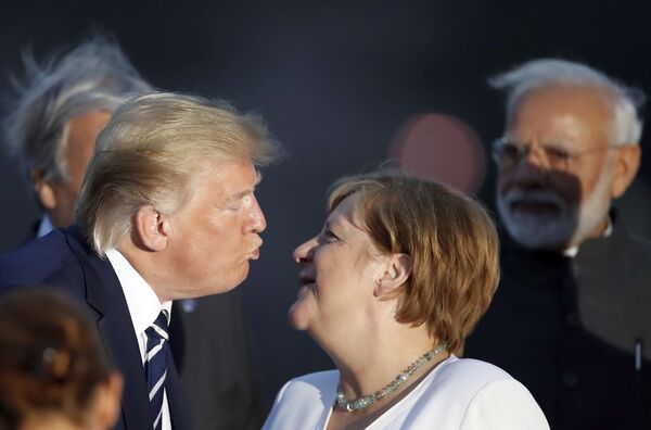 Президент Дональд Трамп целует канцлера Германии Ангелу Меркель во время группового фото G7  - Sputnik Таджикистан