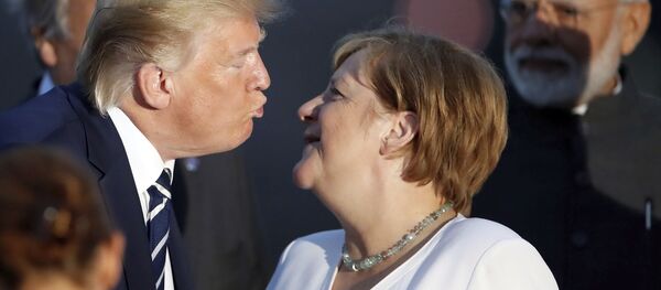 Президент Дональд Трамп целует канцлера Германии Ангелу Меркель во время группового фото G7  - Sputnik Таджикистан