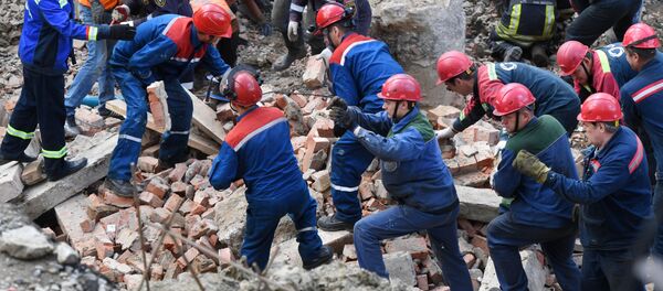Сотрудники МЧС РФ и рабочие разбирают перекрытия, рухнувшие в строящемся здании в Новосибирске - Sputnik Тоҷикистон